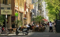 Straße mit Leuten in Cafés